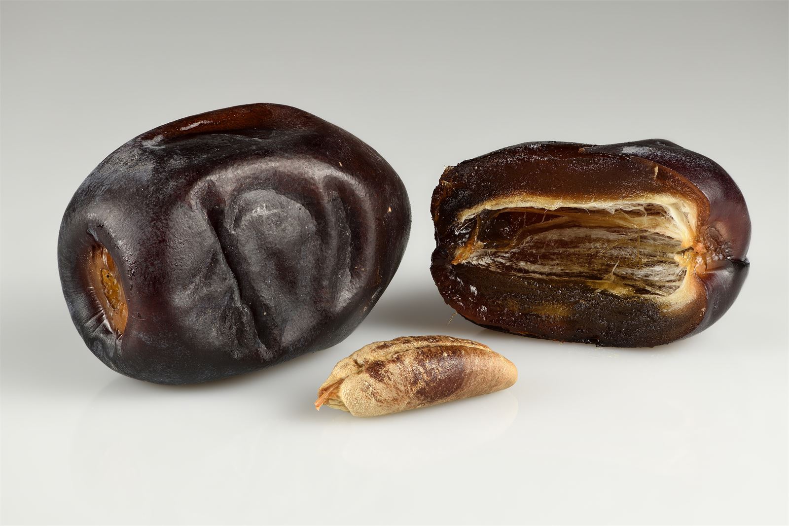 Mazafati dates: a whole fruit, a halved fruit and the seed